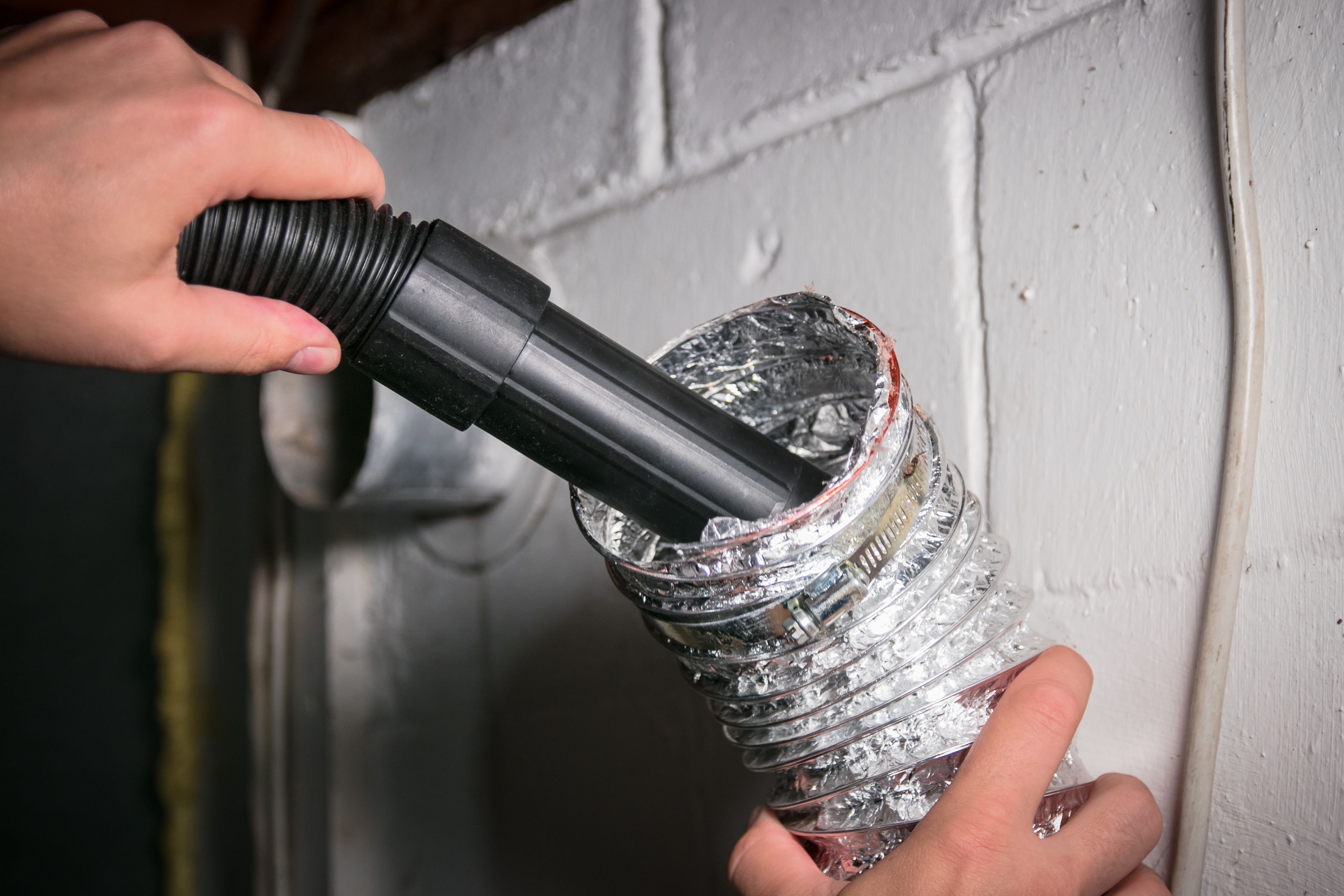 DIY air duct cleaning with a vacuum cleaner hose